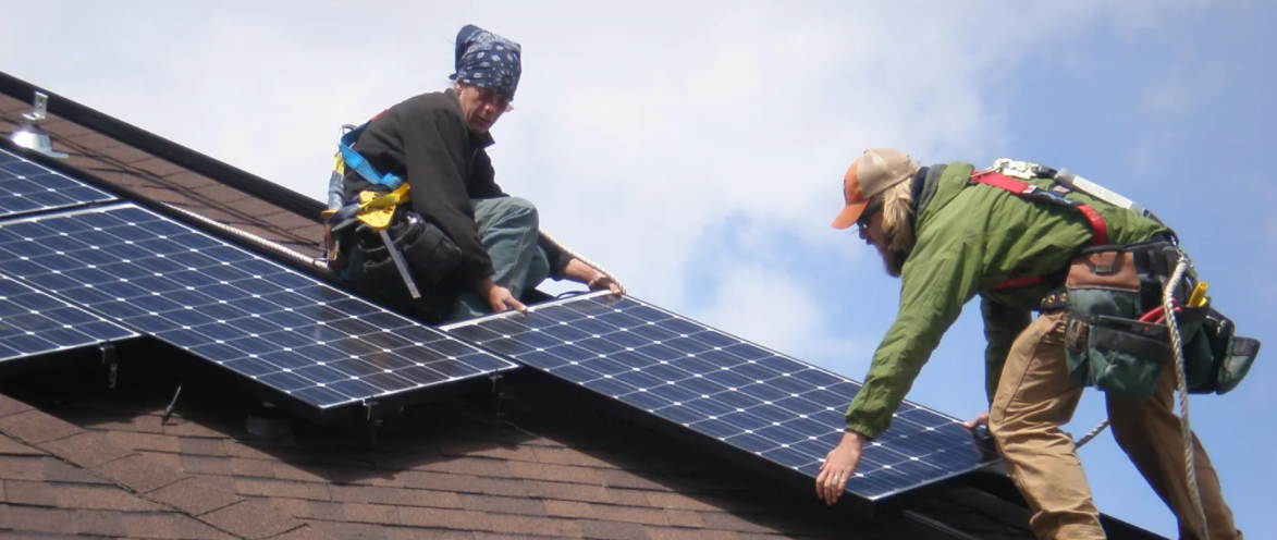 two solar installers on a roof